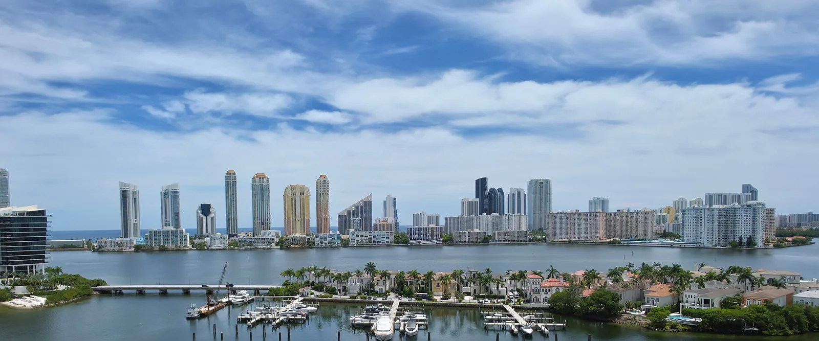 Miami skyline across Biscayne Bay with waterfront homes in the foreground